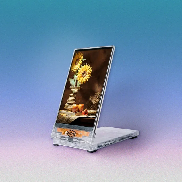 A folding portrait-format Looking Glass Go displaying a still life of sunflowers, fruit and a vase against a blue background.