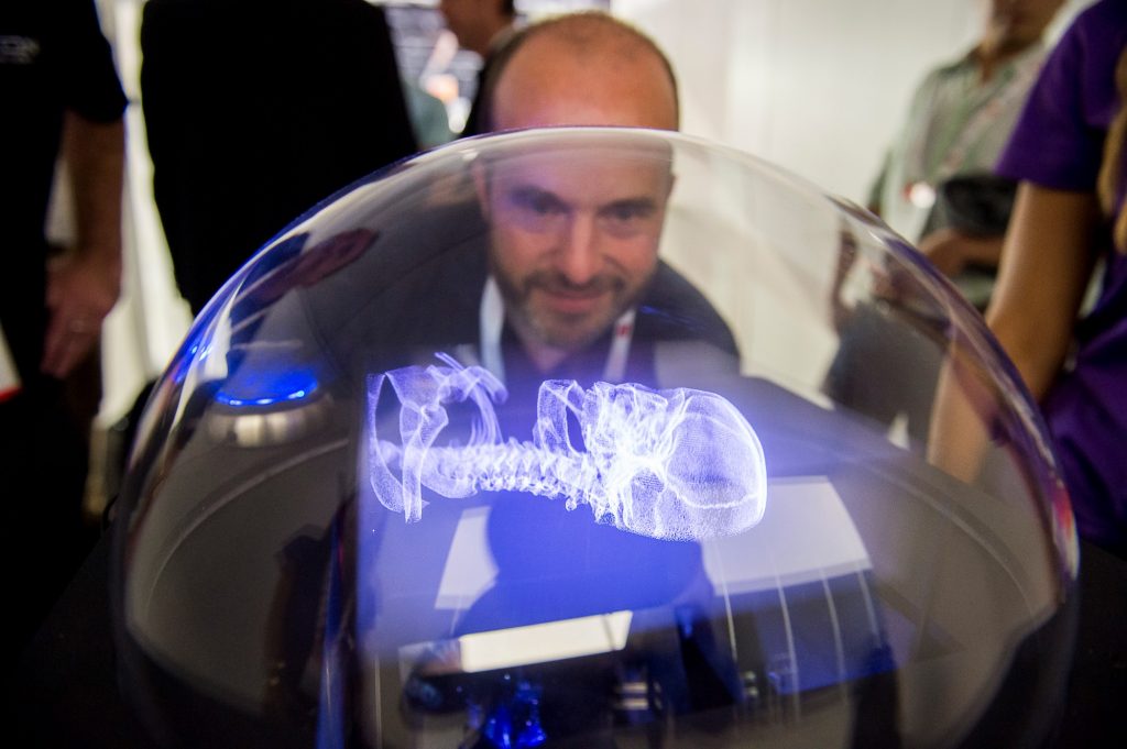 Voxon VX1 displaying a luminous 3D medical dataset inside a transparent dome.